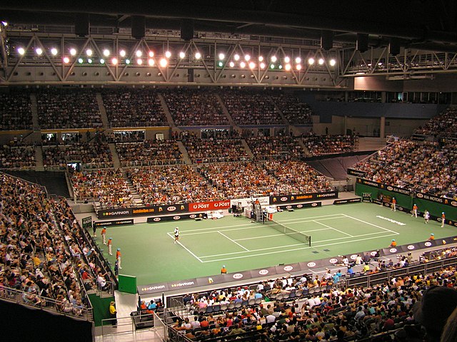 Packed indoor tennis stadium during a match